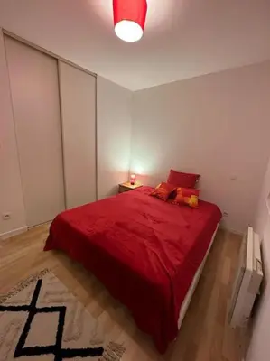 a bedroom with a red bed with a red blanket at Appart T3 centre ville Castres in Castres