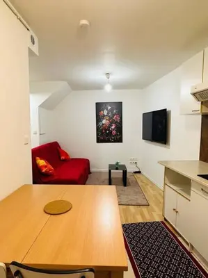 a living room with a table and a red couch at Appart T3 centre ville Castres in Castres