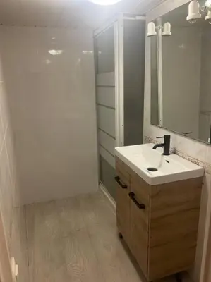 a white bathroom with a sink and a shower at Appart T3 centre ville Castres in Castres