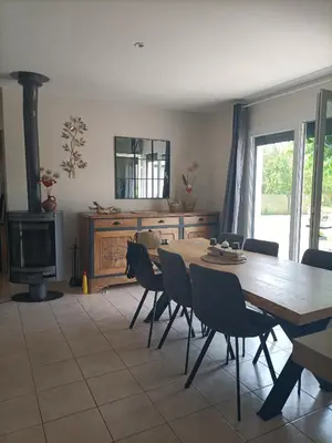 a dining room with a table and chairs and a fireplace at Chambre calme dans une maison à la campagne in Vielmur-sur-Agout
