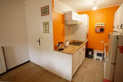 a kitchen with orange walls and a white refrigerator at Gite rue Tranquille in Padern