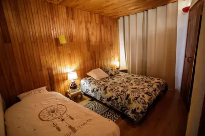 a small room with two beds and two lamps at Gite rue Tranquille in Padern