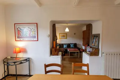 a living room with a table and a couch at Gite rue Tranquille in Padern