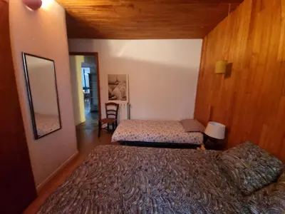 a bedroom with two beds and a mirror at Gite rue Tranquille in Padern