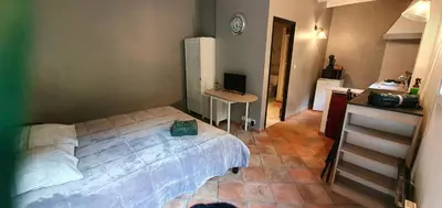 a bedroom with a bed and a desk with a computer at Maison charmante à Narbonne avec piscine et jardin in Narbonne