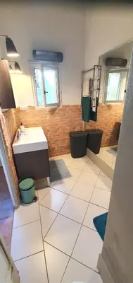 a bathroom with a white tiled floor and a sink at Maison charmante à Narbonne avec piscine et jardin in Narbonne