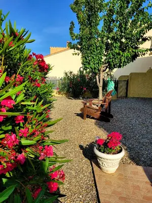 a garden with flowers and a bench and a tree at Gîte Le Bel-Estar in Bélesta