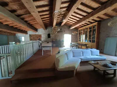 a living room with a white couch and a table at Le Moulin de La Grave - Lagrasse in Lagrasse