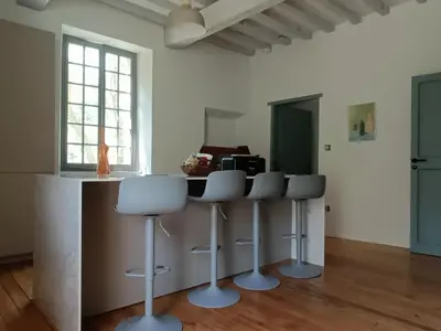 a kitchen with a counter and stools in a room at Le Moulin de La Grave - Lagrasse in Lagrasse