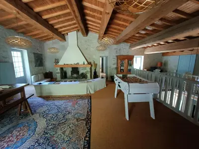 a living room with a table and a fireplace at Le Moulin de La Grave - Lagrasse in Lagrasse