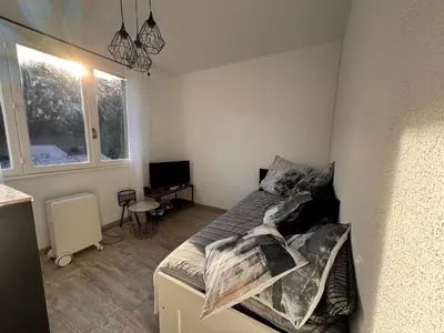 a small bedroom with a bed and a television at Studio Rennes les bains au pied des Thermes in Rennes-les-Bains