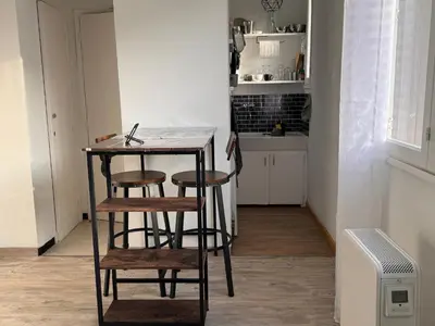 a small kitchen with a table and two stools at Studio Rennes les bains au pied des Thermes in Rennes-les-Bains