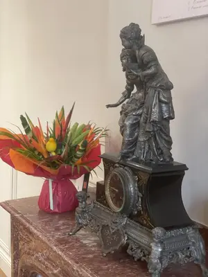 a statue on top of a table with a vase of flowers at La Feuilleraie in Montséret