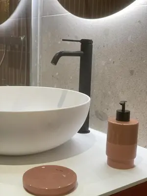 a white sink and a faucet in a bathroom at La Feuilleraie in Montséret