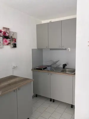 a kitchen with white cabinets and a sink at studio cabine mer in Port-la-Nouvelle