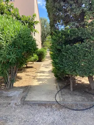 a hose is connected to two trees next to a building at studio cabine mer in Port-la-Nouvelle