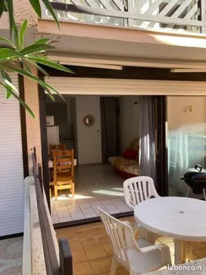 a room with a table and chairs and a dining room at studio cabine mer in Port-la-Nouvelle