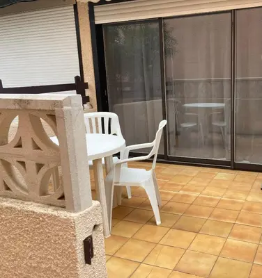 a patio with a white table and chairs on a balcony at studio cabine mer in Port-la-Nouvelle