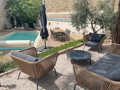 a patio with chairs and a table and a pool at La Petite Ecurie in Montséret