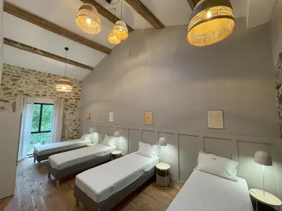 a room with two beds and two tables at La Petite Ecurie in Montséret