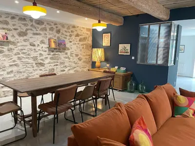 a living room with a wooden table and a couch at La Petite Ecurie in Montséret