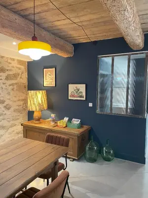 a dining room with a wooden table and a desk at La Petite Ecurie in Montséret