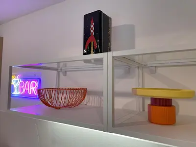 a glass shelf with a bowl and a neon sign at La Petite Ecurie in Montséret