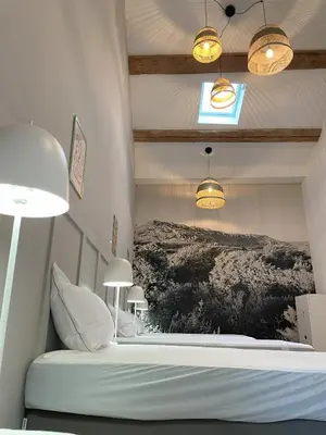 a bedroom with a bed with a picture on the wall at La Petite Ecurie in Montséret