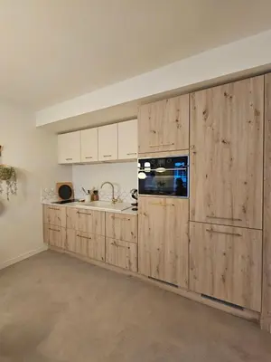 a kitchen with wooden cabinets and a sink at LE JACQUARD Appartement Type 2 proche des Halles in Narbonne