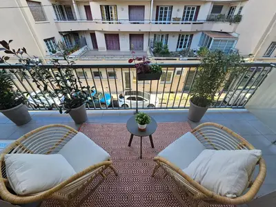 two wicker chairs and a table on a balcony at LE JACQUARD Appartement Type 2 proche des Halles in Narbonne