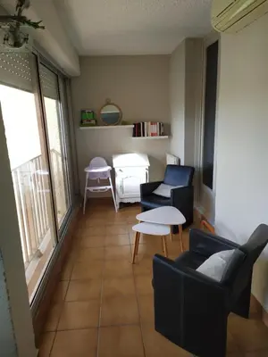 a living room with two chairs and a table at Côté port in Gruissan