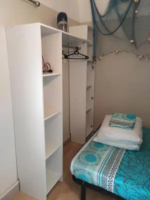 a small bedroom with a bed and a closet at Côté port in Gruissan