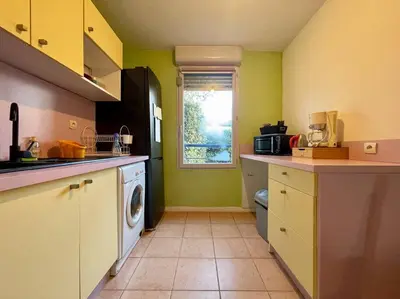 a kitchen with a washing machine and a window at L'appartement Michelet - Parking privé et gratuit - 2km Cité Médiévale in Carcassonne