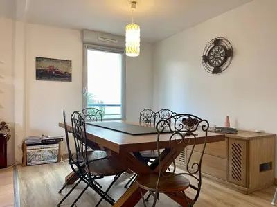 a dining room with a wooden table and chairs at L'appartement Michelet - Parking privé et gratuit - 2km Cité Médiévale in Carcassonne