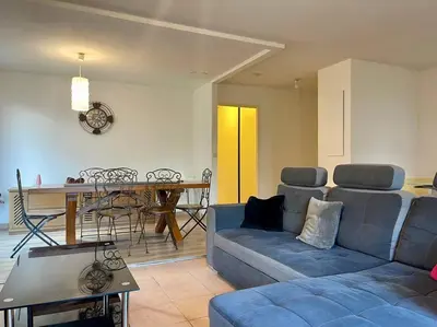 a living room with a couch and a table at L'appartement Michelet - Parking privé et gratuit - 2km Cité Médiévale in Carcassonne