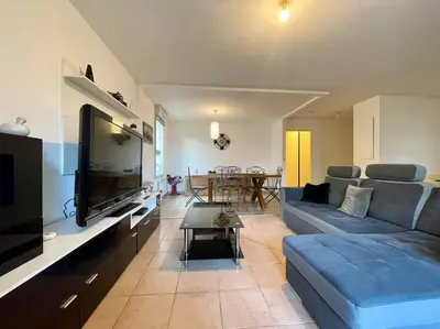 a living room with a blue couch and a tv at L'appartement Michelet - Parking privé et gratuit - 2km Cité Médiévale in Carcassonne