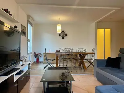 a living room with a couch and a table at L'appartement Michelet - Parking privé et gratuit - 2km Cité Médiévale in Carcassonne