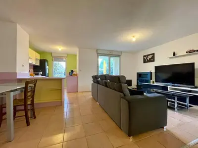 a living room with a couch and a table and a television at L'appartement Michelet - Parking privé et gratuit - 2km Cité Médiévale in Carcassonne
