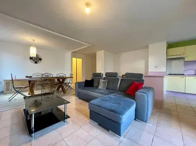 a living room with a blue couch and a table at L'appartement Michelet - Parking privé et gratuit - 2km Cité Médiévale in Carcassonne