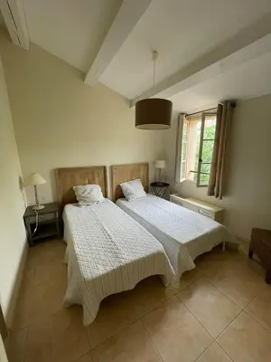 a bedroom with two beds and a window at Maison Kokopetit - Dans les Corbières in Saint-Laurent-de-la-Cabrerisse