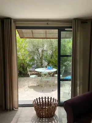 a glass door leading to a patio with a table at Maison Kokopetit - Dans les Corbières in Saint-Laurent-de-la-Cabrerisse