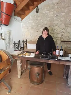 a woman standing at a table with bottles of wine at Sigean - Maison domaine viticole, 6 km de la mer in Sigean