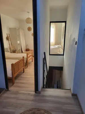 a hallway with a bedroom and a mirror and a bed at Maison de village à la décoration bohème jusqu'à 6 personnes in Viviers-lès-Montagnes