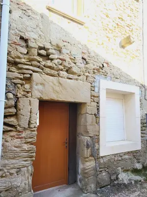 a stone building with a door and a window at Maison de village à la décoration bohème jusqu'à 6 personnes in Viviers-lès-Montagnes