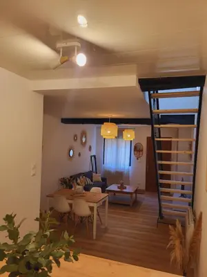 a living room with a table and a couch at Maison de village à la décoration bohème jusqu'à 6 personnes in Viviers-lès-Montagnes