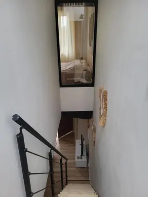 a hallway with a staircase with a mirror and a mirror at Maison de village à la décoration bohème jusqu'à 6 personnes in Viviers-lès-Montagnes