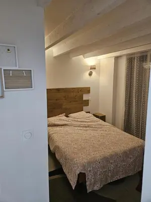 a bedroom with a bed with a wooden headboard at La Bergerie in Narbonne