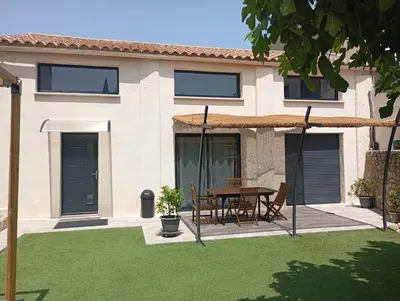 a house with a table and chairs in a yard at La Bergerie in Narbonne