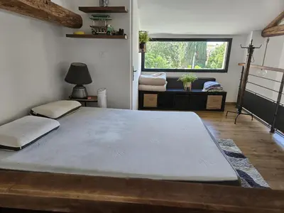 a large bed in a room with a large window at La Bergerie in Narbonne