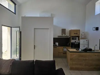 a living room with a couch and a kitchen at La Bergerie in Narbonne